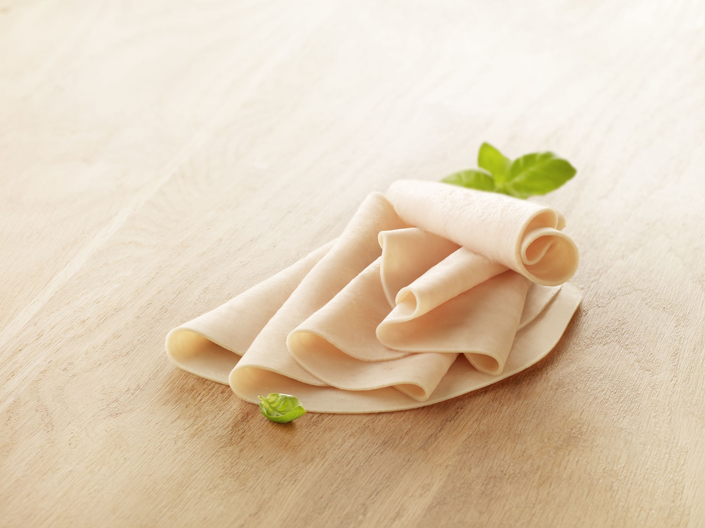 Visuel tranche de blanc de poulet sans nitrite halal sur planche en bois