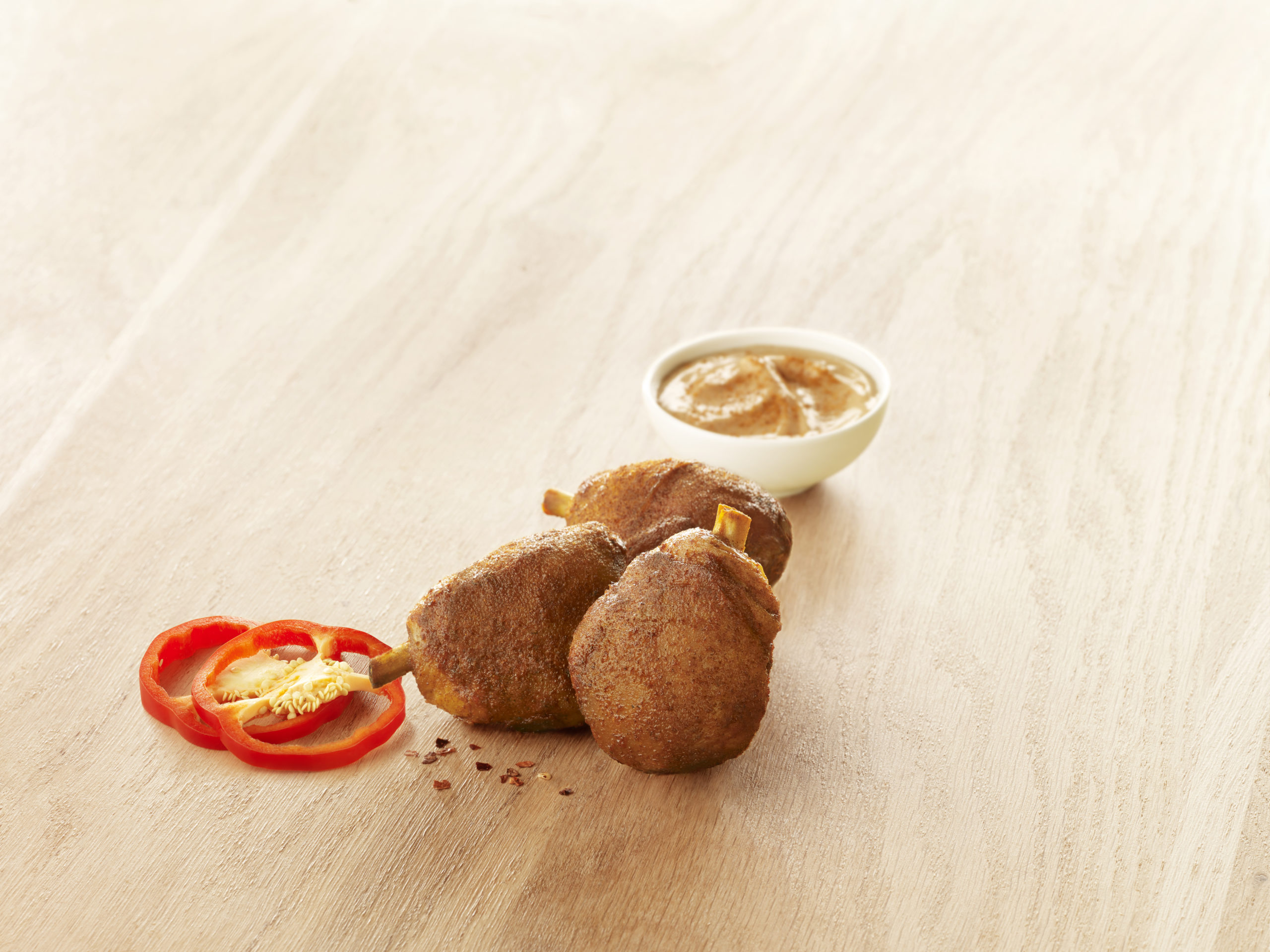 Visuel maxi grignot de poulet à la mexcaine x3 halal sur planche en bois avec sauce