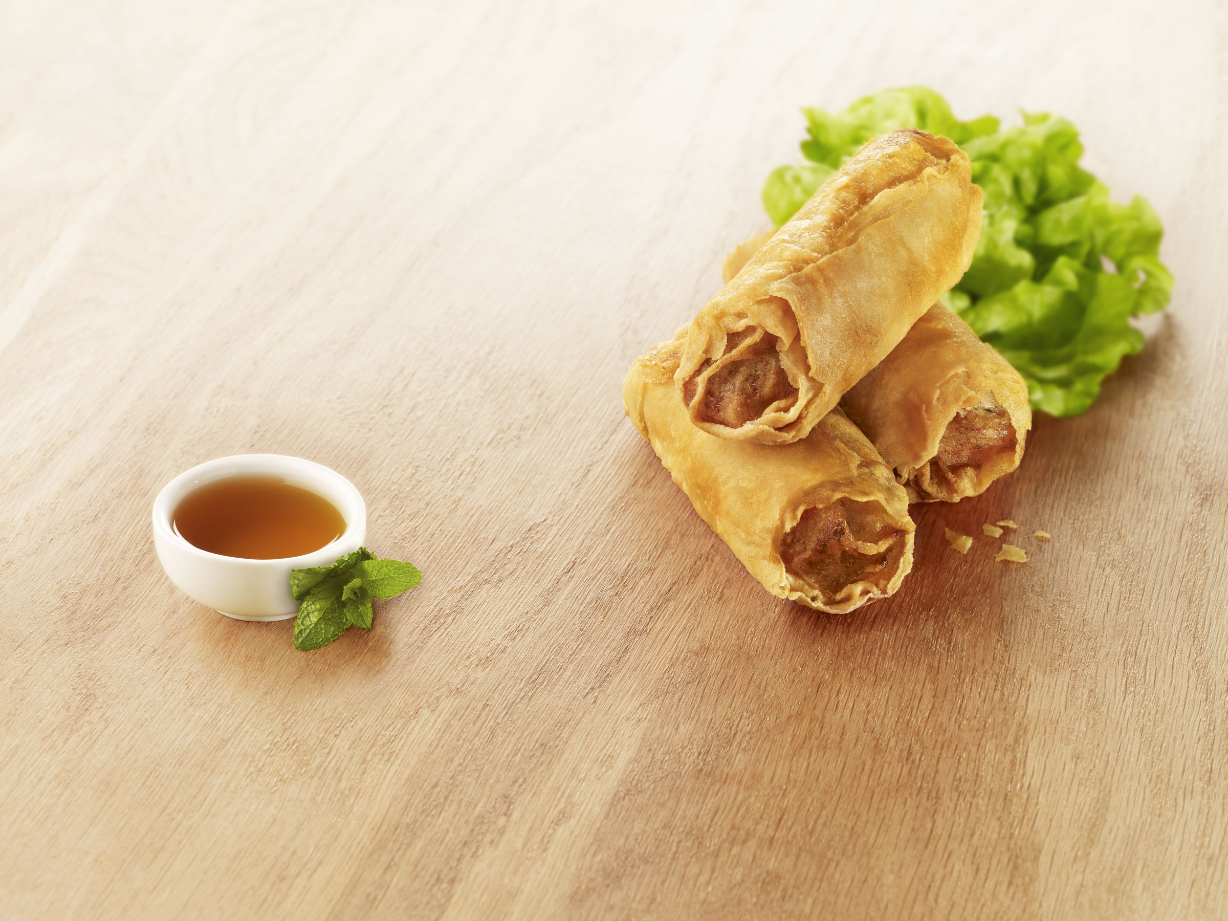 Visuel nems de dinde halal avec sauce et salade sur planche en bois