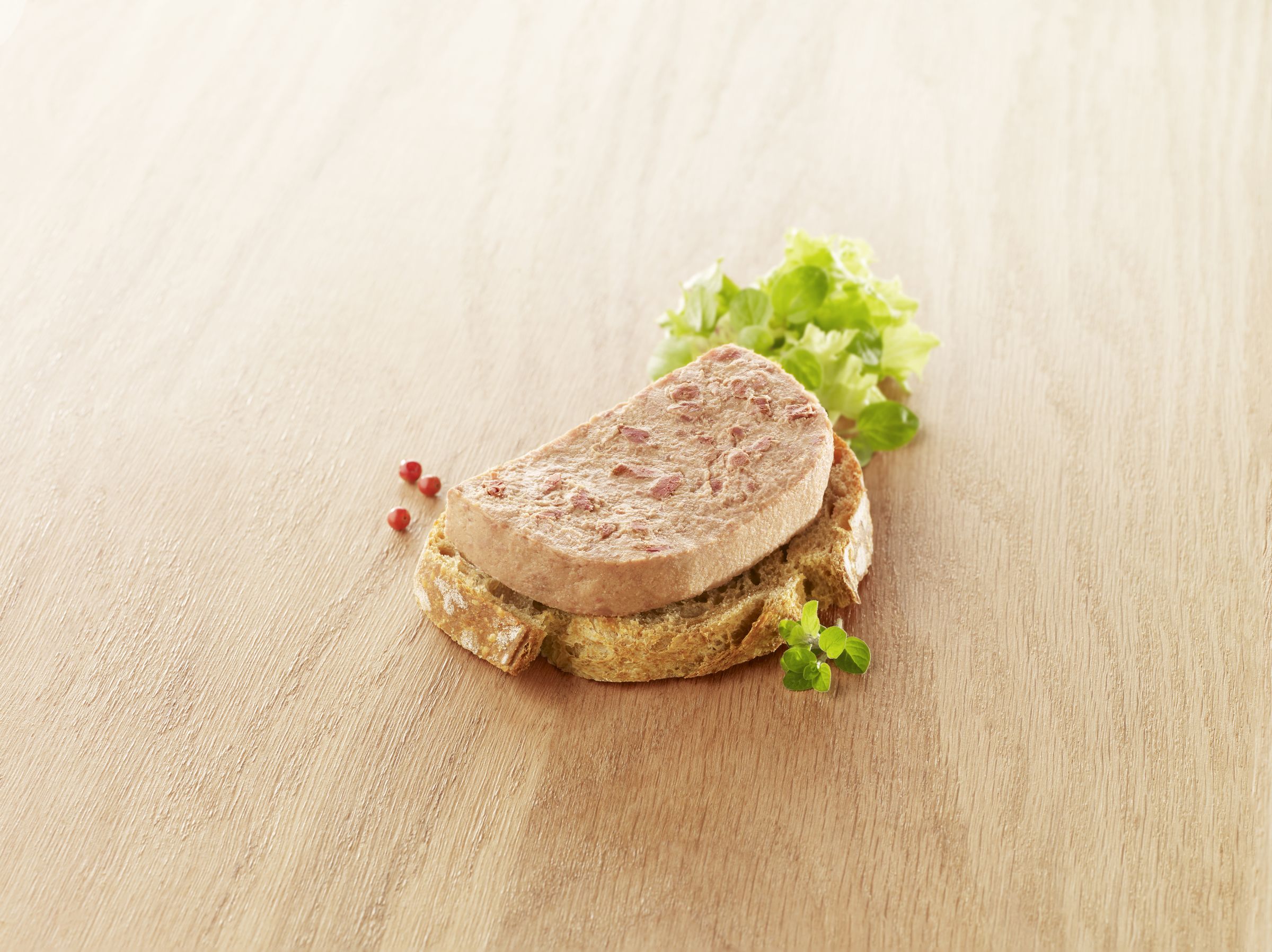 Visuel pâté de volaille halal sur tranche de pain avec salade sur fond bois
