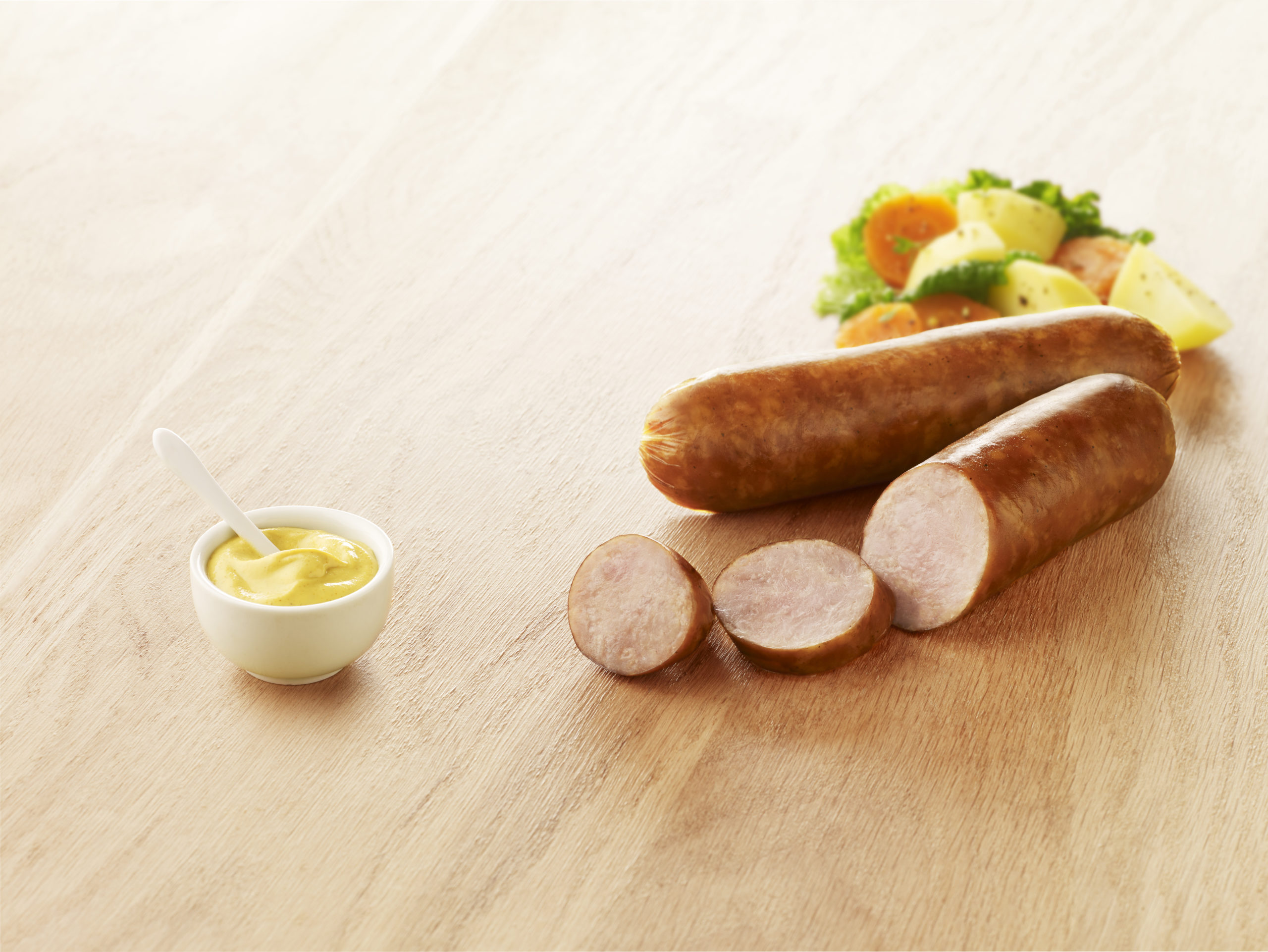 Visuel saucisse de volaille fumées cuites sur planche en bois avec sauce et légumes