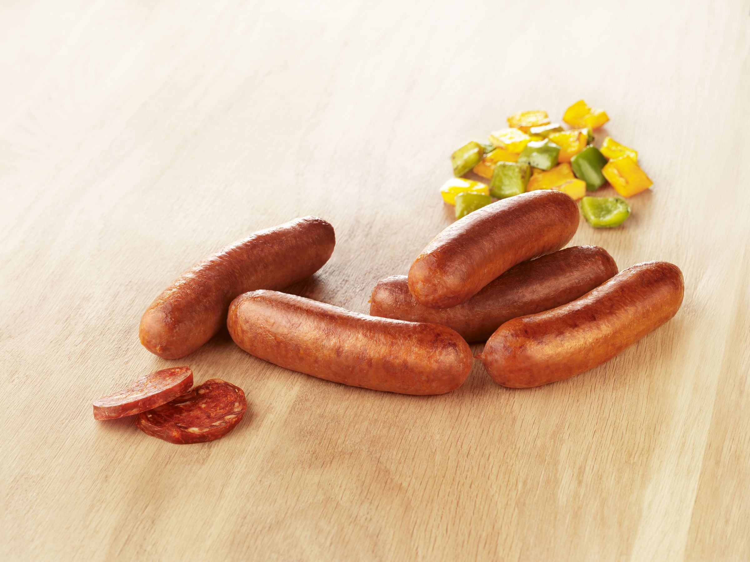 Visuel saucisse de volaille chorizo halal sur planche en bois avec poivrons