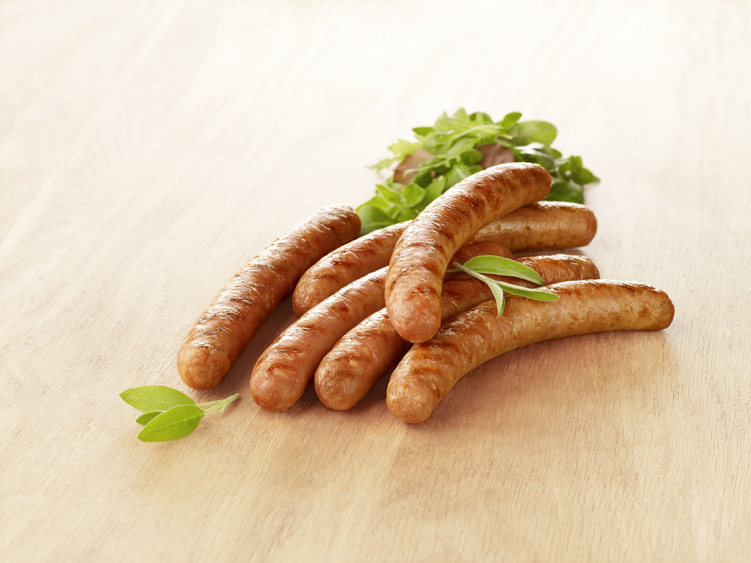 Visuel saucisse de volaille sur planche en bois avec salade