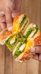 Bagel composé d'aiguillette de poulet à la Milanaise Réghalal, salade et jaune d'œuf coulant.